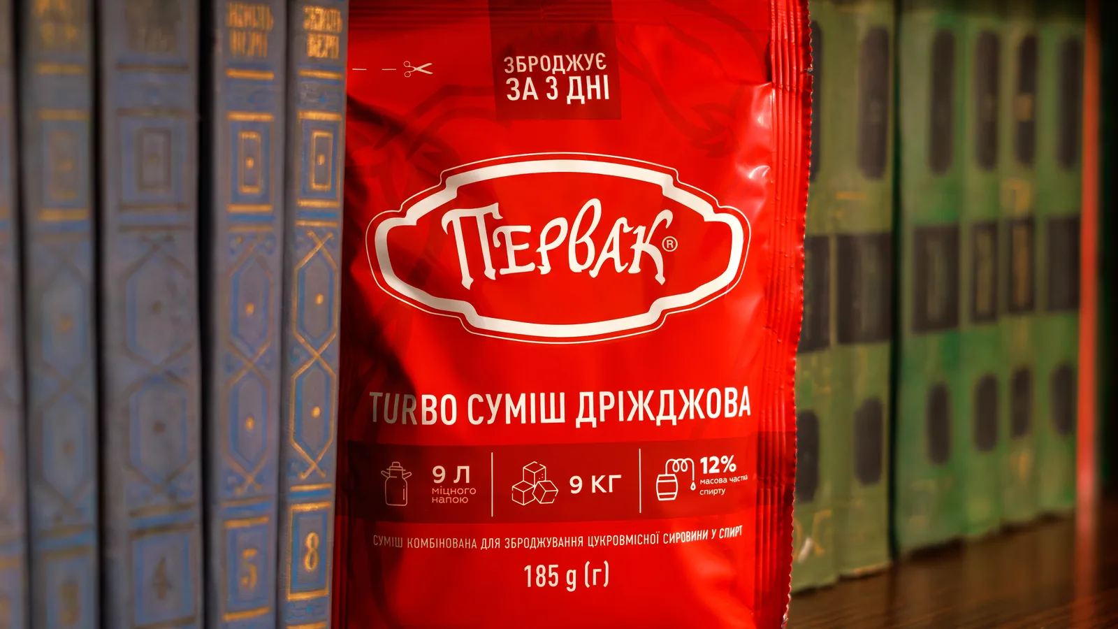 Пакет турбодріжджів Первак на полиці поруч зі старими книгами